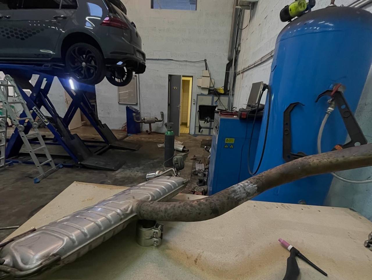 Ligne d'échappement sur établi – vue atelier avec voiture